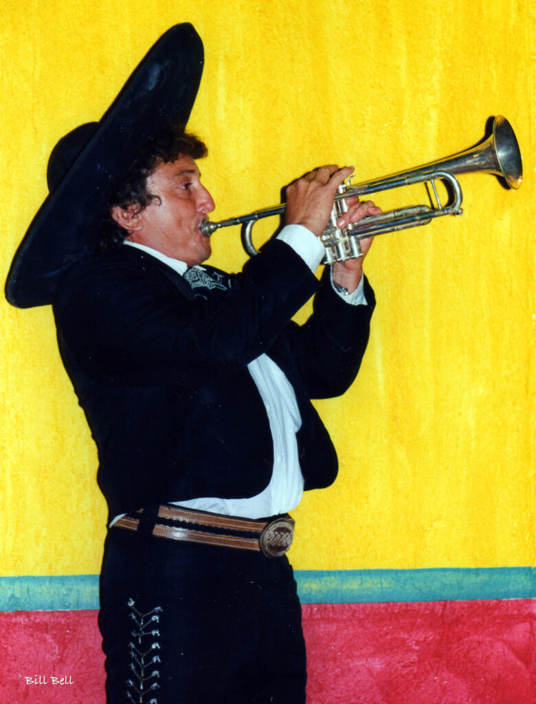 Capturing the essence of Mexican music, this mariachi trumpeter showcases his musical talent against a vivid yellow background.