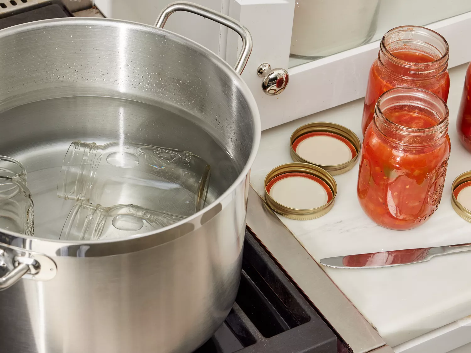 Sterile jars filled with salsa, leaving 1/4 of an inch from the top.